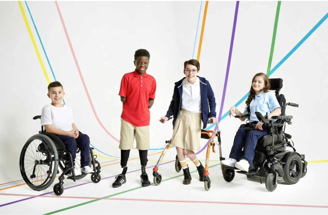 Group of kids with and without mobility devices standing together