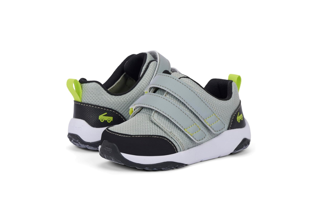 Gray See Kai Run kids adaptive sneaker with wide opening for AFO and SMO orthotics. The shoe has a white sole with black and neon green accents.