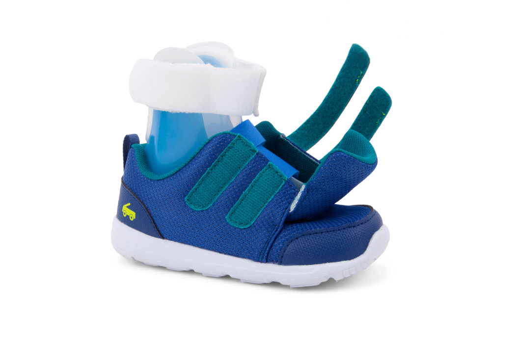 See Kai Run Adaptive kids sneakers in blue shown with the velcro closures and wide opening for easy on/off. There is an SMO orthotic shown in the shoe.