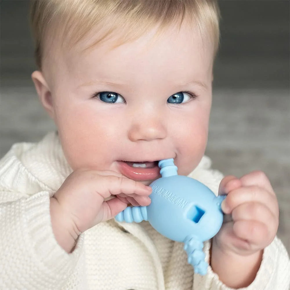 Baby chewing on a light blue Molar Magician silicone sensory teether, close-up