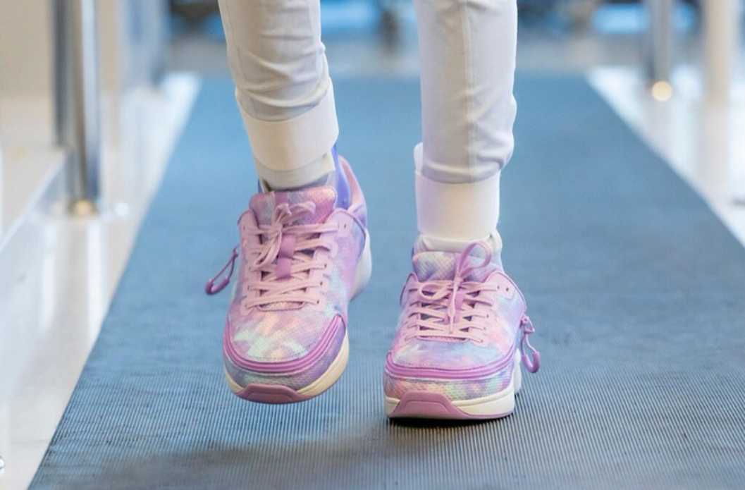 Child wearing BILLY shoes while walking on a rubber path, demonstrating an AFO-friendly shoe with extra depth and a wide-opening design.