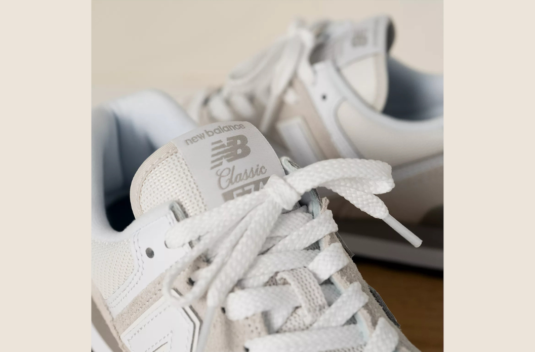 White New Balance 574 sneaker with removable insole and laces, recommended as a versatile school shoe for orthotics and braces.