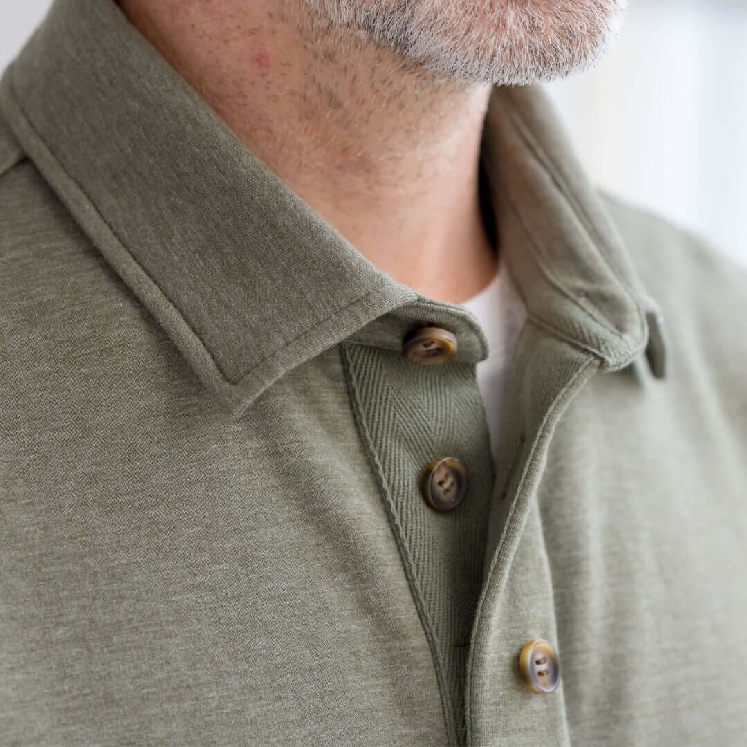 Close-up of a person wearing MagnaReady heathered olive sweatshirt collar and magnetic closure detail.