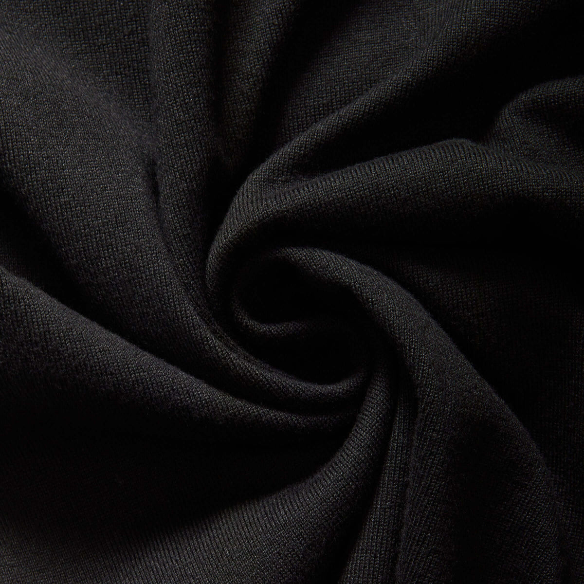 Close-up of MagnaReady black cardigan knit fabric with folds.