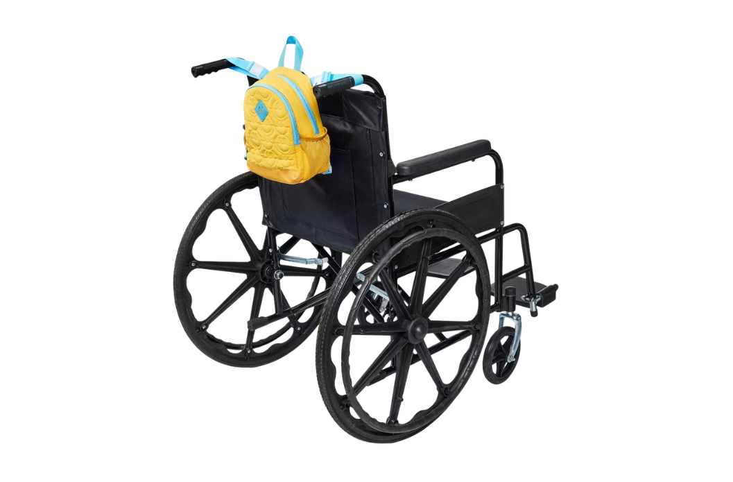 Small yellow and turquoise backpack hanging from the push handles of a manual wheelchair, side view