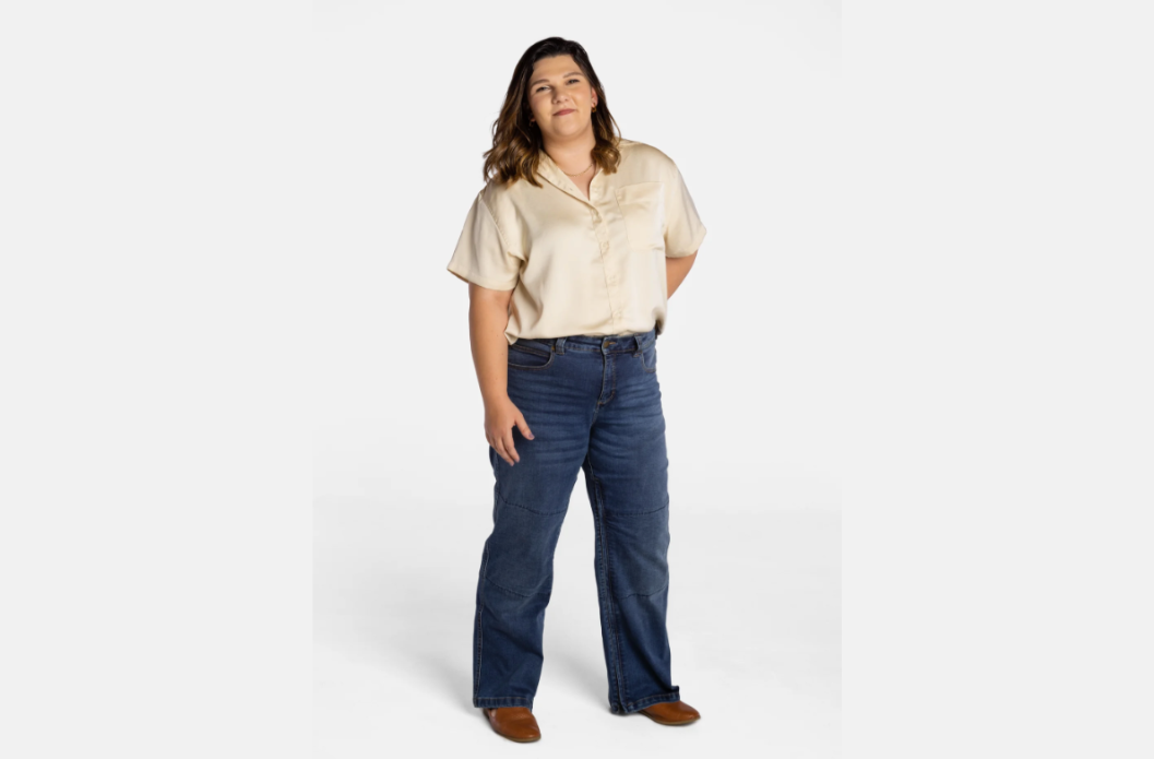 Woman wearing No Limbits wide-leg adaptive jeans in dark wash with articulated knee panels, front view